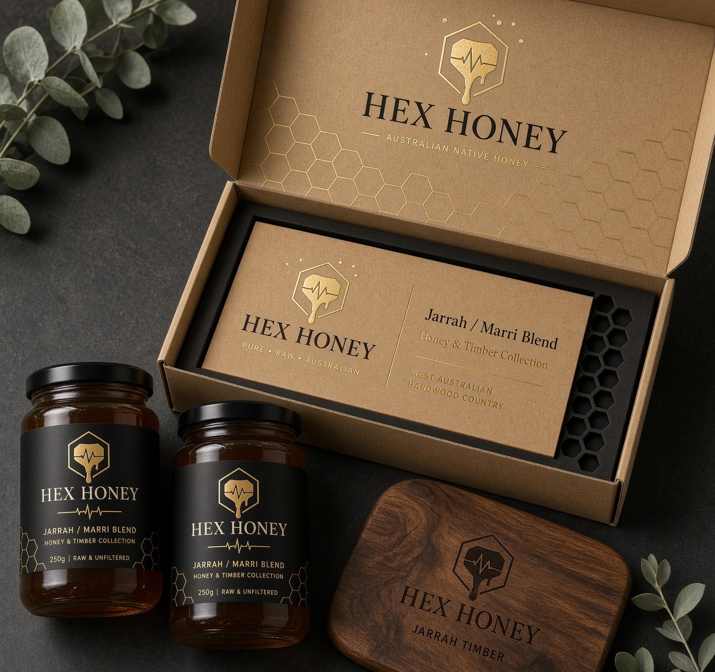 Brand mockup of an open kraft box with two honey jars and a small jarrah board.